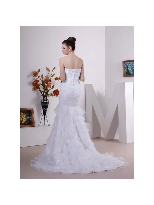 Abito da sposa a sirena molto aderente con balze in organza sulla gonna