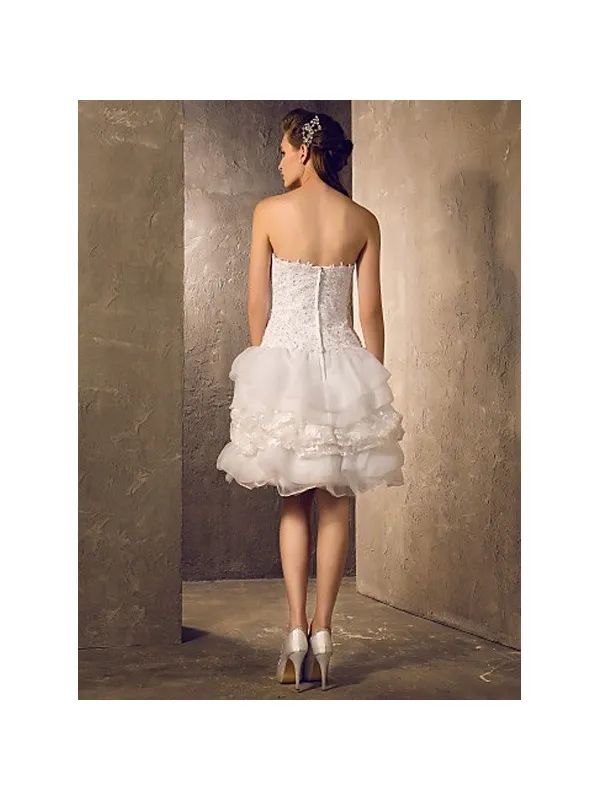 Abito da sposa corto con gonna voluminosa e corpetto a vita bassa in pizzo