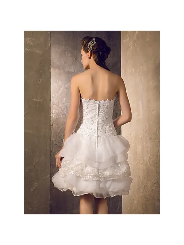 Abito da sposa corto con gonna voluminosa e corpetto a vita bassa in pizzo